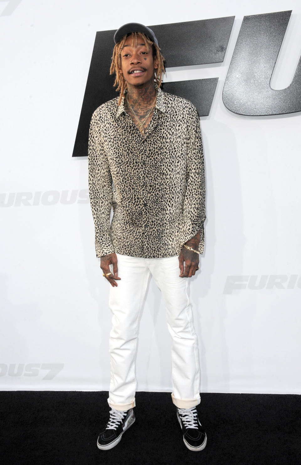 Looking perfectly preppy in white denim, a beat up baseball cap, and boat shoes, the rapper added some street flair with a cheetah print button down and neck tattoos.