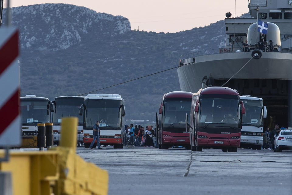 Migrants wait to board on buses after their disembarkation at the port of Elefsina, near Athens, on Saturday, Nov. 2, 2019. The transfer of migrants from overcrowded camps on the islands to the Greek mainland continued this weekend, with 415 arriving Saturday afternoon at the port of Elefsina west of Athens and at least another 400 expected Sunday or early Monday. (AP Photo/Yorgos Karahalis)