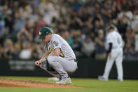 Oakland Athletics starting pitcher Chris Bassitt crouches by the mound after he gave up a two-run home run to Seattle Mariners' Mitch Haniger during the fifth inning of a baseball game Saturday, July 24, 2021, in Seattle. (AP Photo/Ted S. Warren)