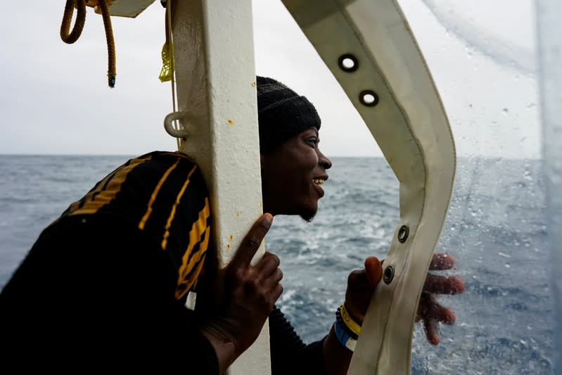 A migrant looks at the island of Sicily on board a NGO Proactiva Open Arms rescue boat in the central Mediterranean Sea