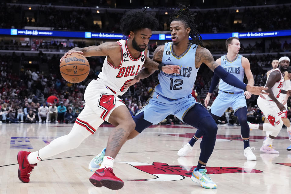 Chicago Bulls guard Coby White, left, drives as Memphis Grizzlies guard Ja Morant guards during the first half of an NBA basketball game in Chicago, Sunday, April 2, 2023. (AP Photo/Nam Y. Huh)