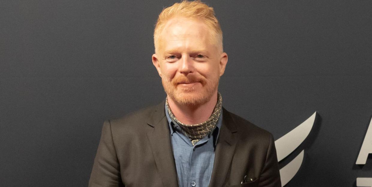 jesse tyler ferguson, a man stands looking at the camera smiling