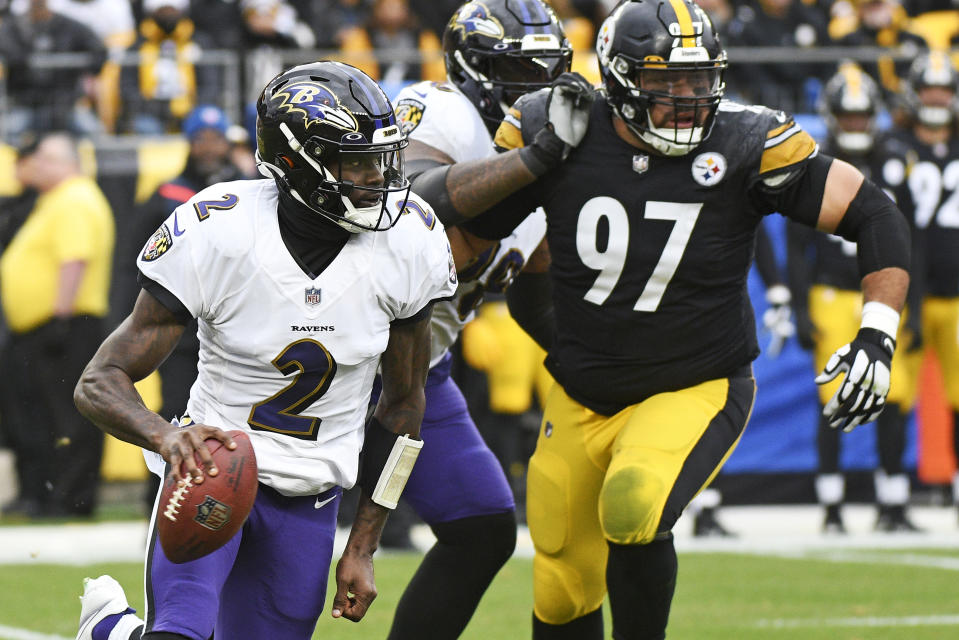 Baltimore Ravens quarterback Tyler Huntley (2) scrambles out of the pocket with Pittsburgh Steelers defensive tackle Cameron Heyward (97) in pursuit during the first half of an NFL football game in Pittsburgh, Sunday, Dec. 11, 2022. (AP Photo/Don Wright)