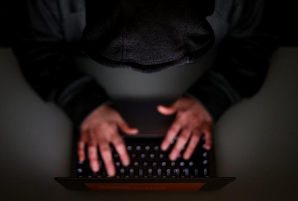 A laptop user with their hood up (Tim Goode/PA) (PA Archive)