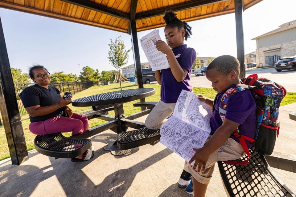 LaShanta Mire, left, helps her daughter Malaysia Campbell, 8, and her son Terrance Mire, 4, build their reading skills at the park in the Patriot Pointe Apartments in Fort Worth on Wednesday. After taking a reading assessment over the summer, Campbell was told she has a kindergarten reading level as a third grader despite coming home with A’s on her report cards.