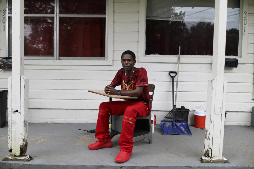 FILE - In this Saturday, June 8, 2019, file photo, Joshua Love sits on his front porch in his "thinking chair," a classroom desk and chair he recently salvaged from a dumpster, in Greenwood, Miss. "I guess there's a child inside of me that still wants to sit there and learn," he says. Love and his cousin, La Jarvis, have accused Paul A. West, once a Franciscan friar and fourth-grade teacher, of molesting them while they were elementary-school students. (AP Photo/Wong Maye-E, File)