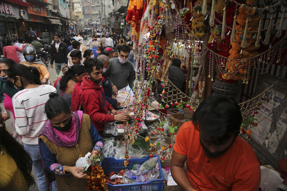 Indians wearing face masks as a precautionary measure against the coronavirus shop during Diwali, the Hindu festival of lights, in Jammu, India, Saturday, Nov. 14, 2020. (AP Photo/ Channi Anand)