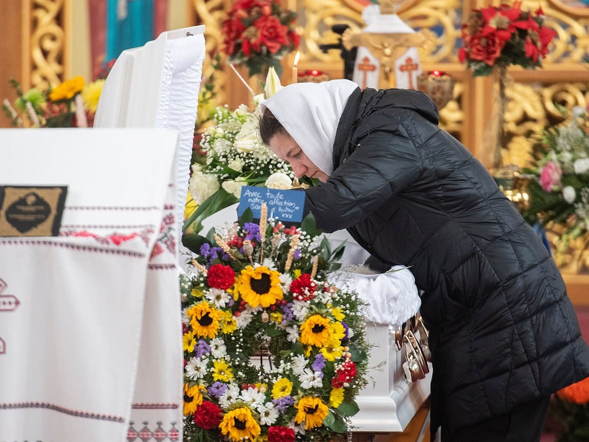 Halyna Lehenkovska, mother of seven-year-old Mariia Lehenkovska, leans over her daughter's casket during her funeral in Montreal, Wednesday. (Graham Hughes/The Canadian Press - image credit)