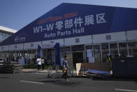 A worker walks for the upcoming auto show to be held in Beijing, China, Wednesday, April 24, 2024. Foreign automakers have been caught flat-footed in China by an electric vehicle boom that has shaken up the market over the last three years. That has left manufacturers like Volkswagen scrambling to develop new models for a very different market than at home. (AP Photo/Tatan Syuflana)