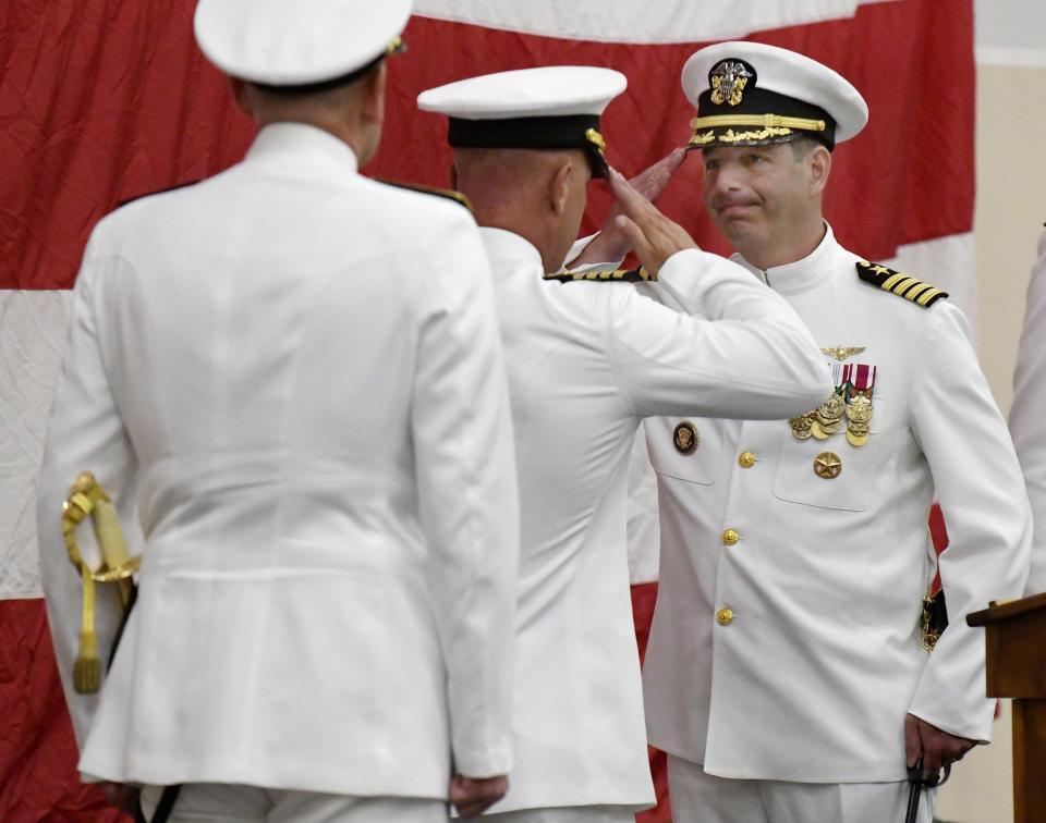 Capt. Brian Binder, right, salutes Capt. Jason Canfield as Binder officially takes over the role of base commander at Naval Station Mayport during Friday's change of command ceremony.