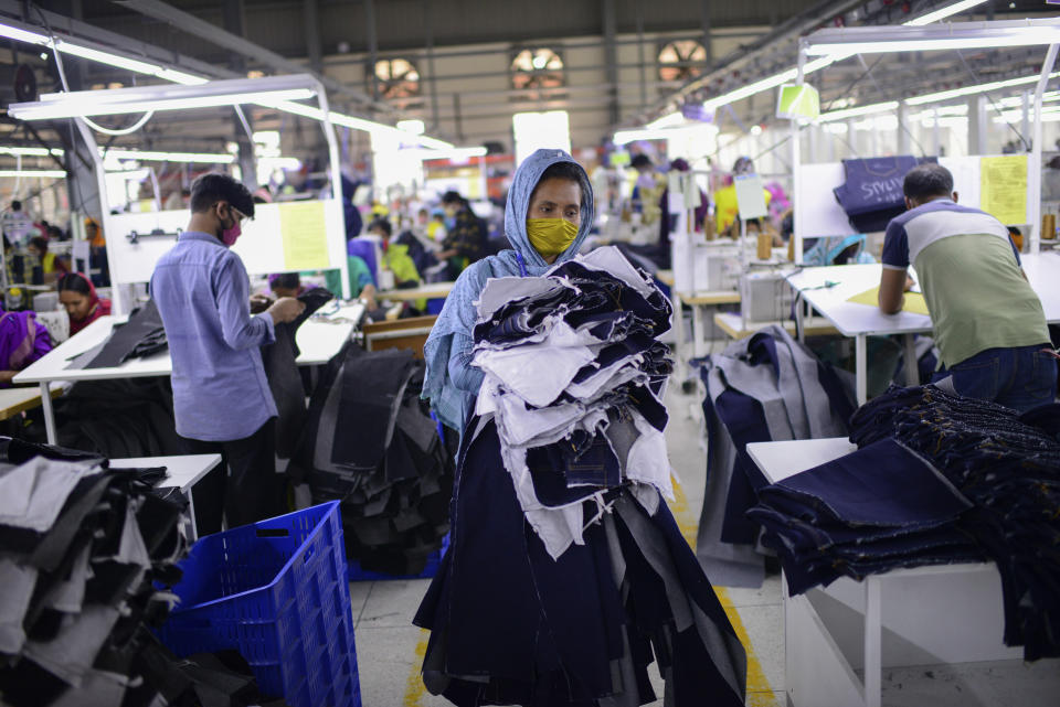 FILE - Garment factory employees work at Arrival Fashion Ltd. in Gazipur, Bangladesh, Saturday, March 13, 2021. Bangladesh's economic miracle is under severe strain as fuel price hikes amplify public frustrations over rising costs for food and other necessities. (AP Photo/Mahmud Hossain Opu, File)