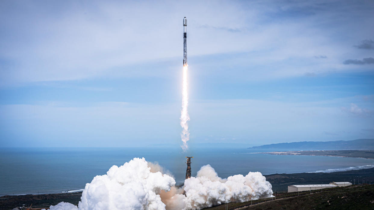  A black-and-white spacex falcon 9 rocket launches into a blue sky. 