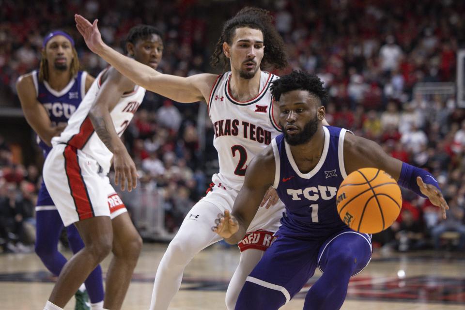 TCU's Mike Miles Jr. (1) gathers a loose ball as Texas Tech's Pop Isaacs (2) defends during the second half of an NCAA college basketball game, Saturday, Feb. 25, 2023, in Lubbock, Texas. (AP Photo/Chase Seabolt)