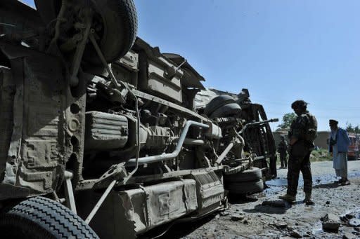 French soldiers with the NATO-led International Security Assistance Force (ISAF) look at the scene where a civilian minibus was hit by a remote-controlled bomb in Paghman district of Kabul