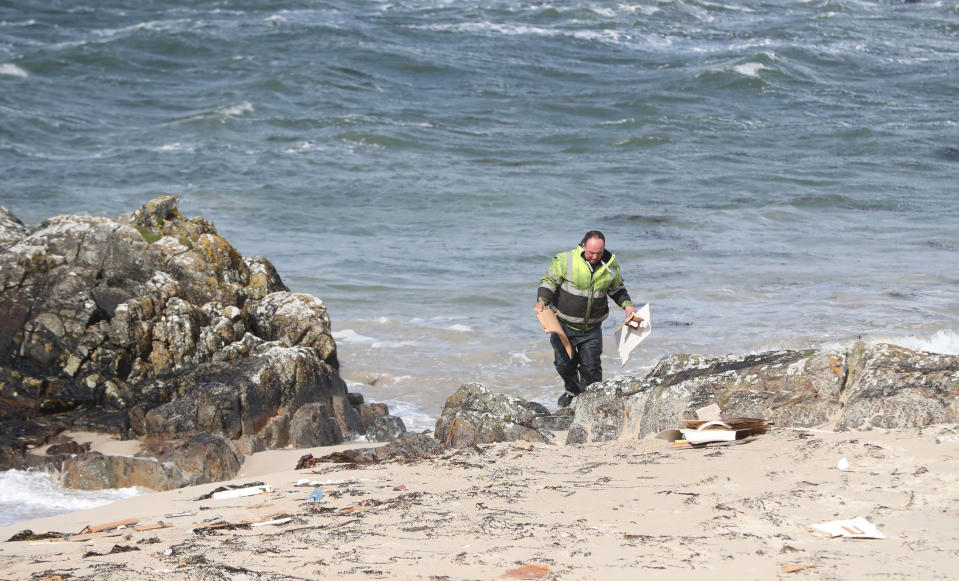 A man picks up debris at the scene. (Photo by Niall Carson/PA Images via Getty Images)