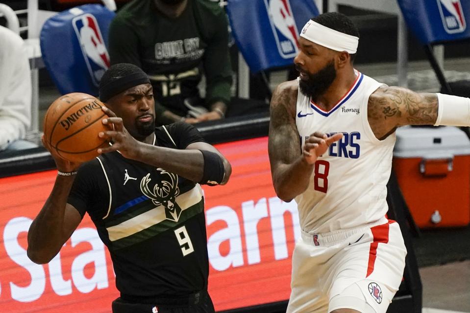 Milwaukee Bucks' Bobby Portis looks to pass around LA Clippers' Marcus Morris Sr. during the first half of an NBA basketball game Sunday, Feb. 28, 2021, in Milwaukee. (AP Photo/Morry Gash)