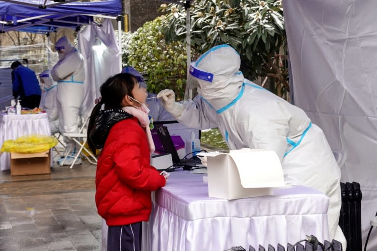 Des résidents de la ville de Xi'an, dans le nord de la Chine, en quarantaine, passent des tests Covid-19 le 25 décembre 2021 (AFP/STR)