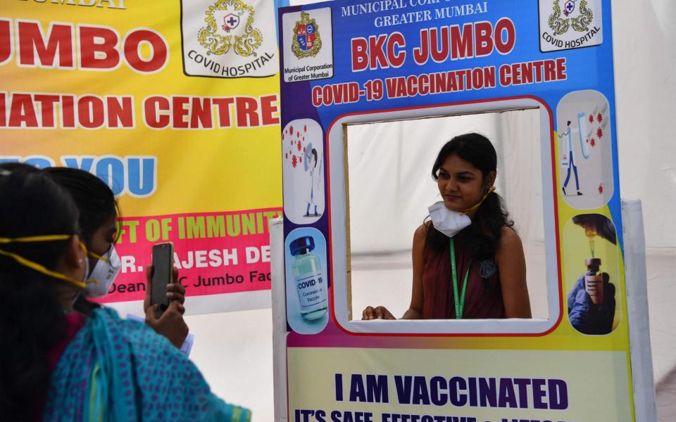 Police personnel take pictures after receiving a -19 coronavirus vaccine at a vaccination centre in Mumbai - Indranil Mukherjee/AFP