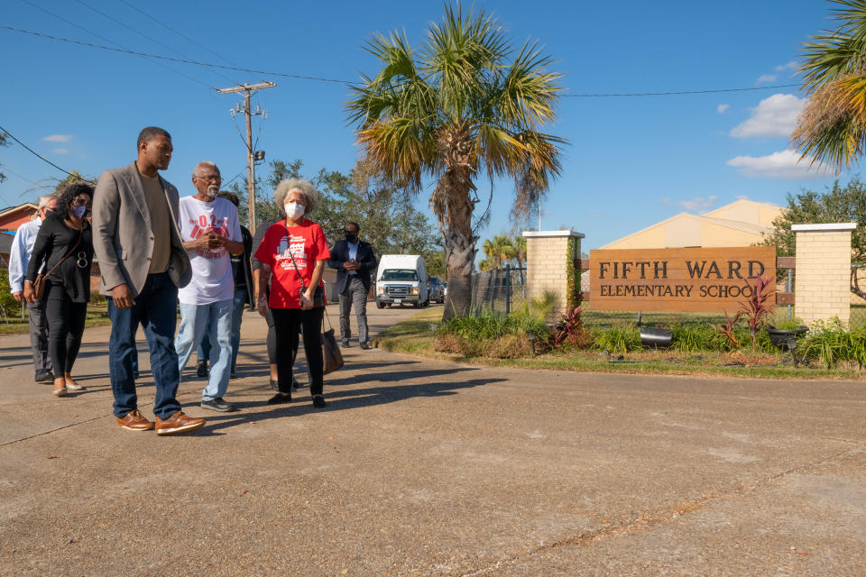 Michael Regan, left, with Robert Taylor, center wearing a white and red T-Shirt, and other community members outside Fifth Ward Elementary School. (Eric Vance / USEPA)