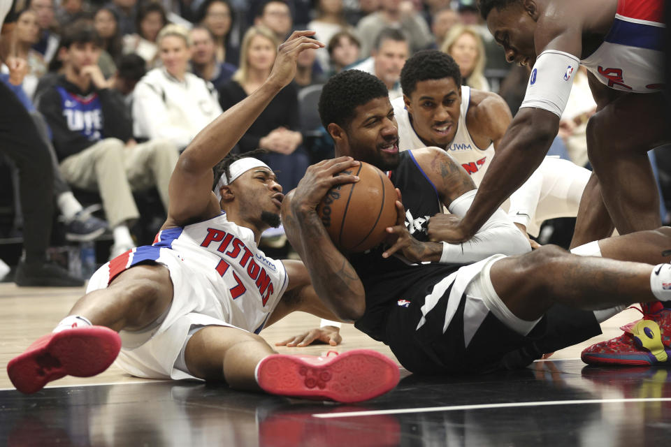 Los Angeles Clippers forward Paul George, center, vies for a loose ball with Detroit Pistons guard Stanley Umude during the first half of an NBA basketball game Saturday, Feb. 10, 2024, in Los Angeles. (AP Photo/Raul Romero Jr. )