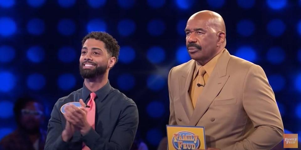 Kevin Burgo, left, plays the Fast Money round while "Family Feud" host Steve Harvey reads off his answers.