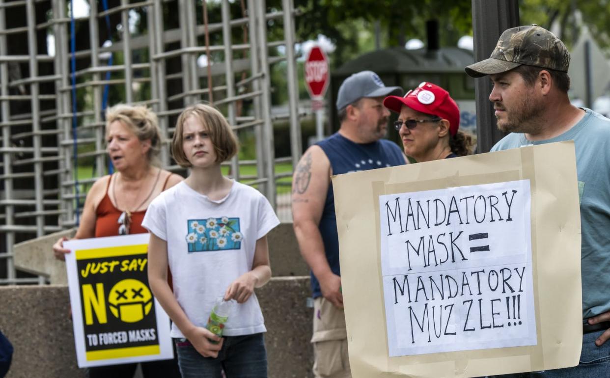 <span class="caption">Protestors hold anti-mask signs at a protest in St. Paul, Minnesota.</span> <span class="attribution"><a class="link " href="https://www.gettyimages.com/detail/news-photo/st-paul-minnesota-protest-to-unmask-minnesota-protesters-news-photo/1264513480?adppopup=true" rel="nofollow noopener" target="_blank" data-ylk="slk:Education Images/Getty Images;elm:context_link;itc:0;sec:content-canvas">Education Images/Getty Images</a></span>