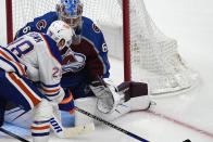 Edmonton Oilers right wing Connor Brown, front, looks to shoot against Colorado Avalanche goaltender Justus Annunen during the third period of an NHL hockey game Thursday, April 18, 2024, in Denver. (AP Photo/David Zalubowski)