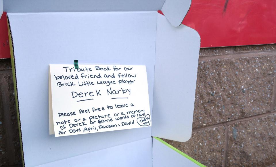 A tribute book and donation box for former Brick Little League player Derek Narby rests outside the snack window at the Cherry Quay fields Wednesday evening, September 20, 2023. State Police are still searching for his body in the Manasquan Inlet after the boat he was in was capsized there last Thursday.