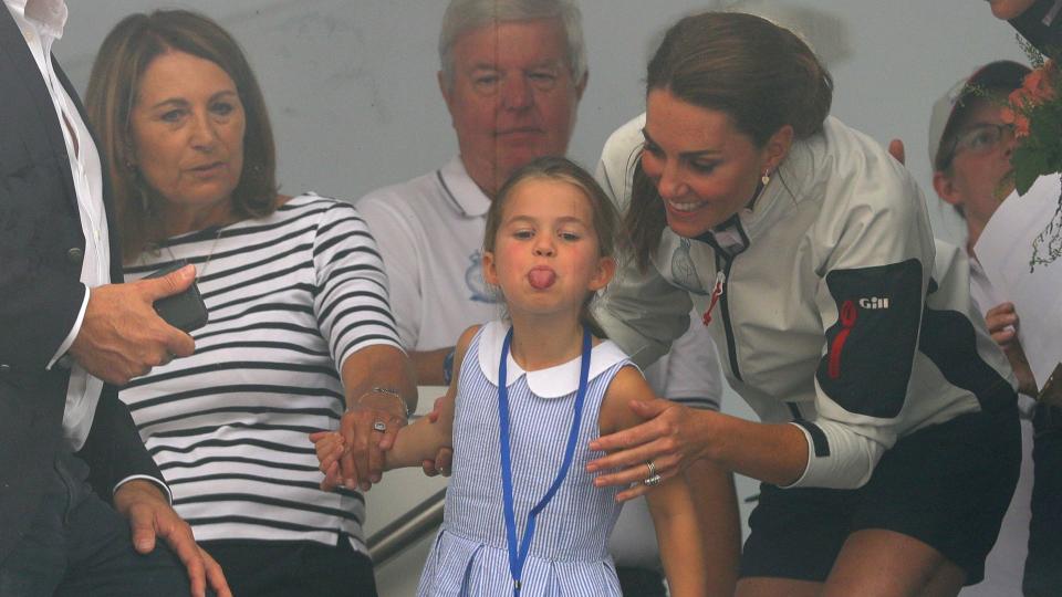 Kate with Princess Charlotte and Carole Middleton look through a window at the prize giving after the King's Cup regatta at Cowes on the Isle of Wight