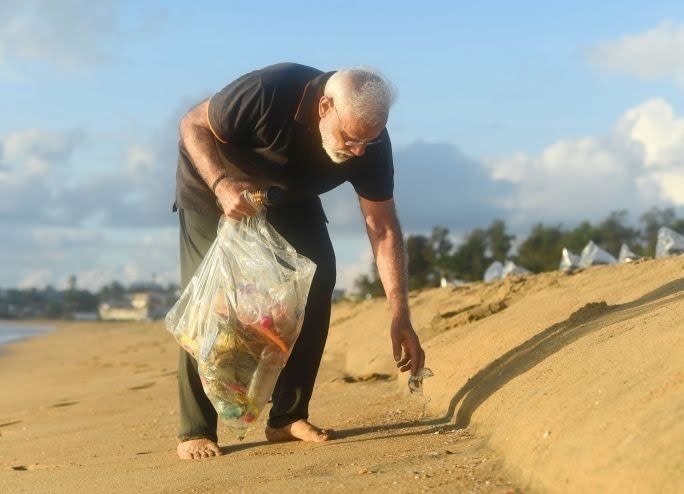 In this handout photo provided by the Indian Prime Minister's Office, Prime Minister Narendra Modi picks trash from a beach in Mamallapuram, India. As part of his cleanliness drive, Indian Prime Minister Narendra Modi has picked up trash from a beach in the southern temple town where he hosted Chinese President Xi Jinping. (Indian Prime Minister's Office via AP)