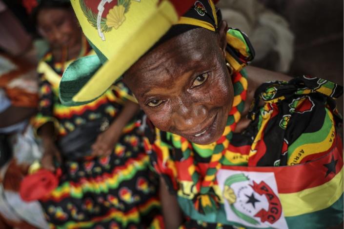 A woman wears a dress, hat and necklace in colours of the Inclusive Alliance Platform party in Bissau, Guinea-Bissau - Monday 29 May 2023