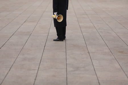 A security agent holds a megaphone at Tiananmen Square a day before the 19th National Congress of the Communist Party of China begins in Beijing, China, October 17, 2017. REUTERS/Damir Sagolj