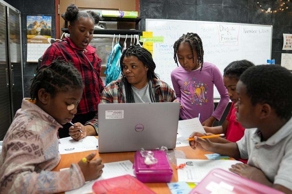 Latoria McNeil, a social work intern, helps third grade students with spelling and alphabetization Wednesday, Nov. 1, 2023, during the Read to Lead after school program at the MLK Center in Indianapolis. The program offers reading enrichment and tutoring for students from James Whitcomb Riley Elementary School, with the goal of improving their skills and sparking a love of reading.