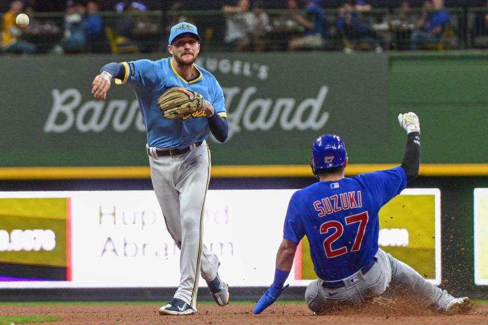 Milwaukee Brewers second baseman Brice Turang completes a double play after forcing out Chicago Cubs baserunner Seiya Suzuki.