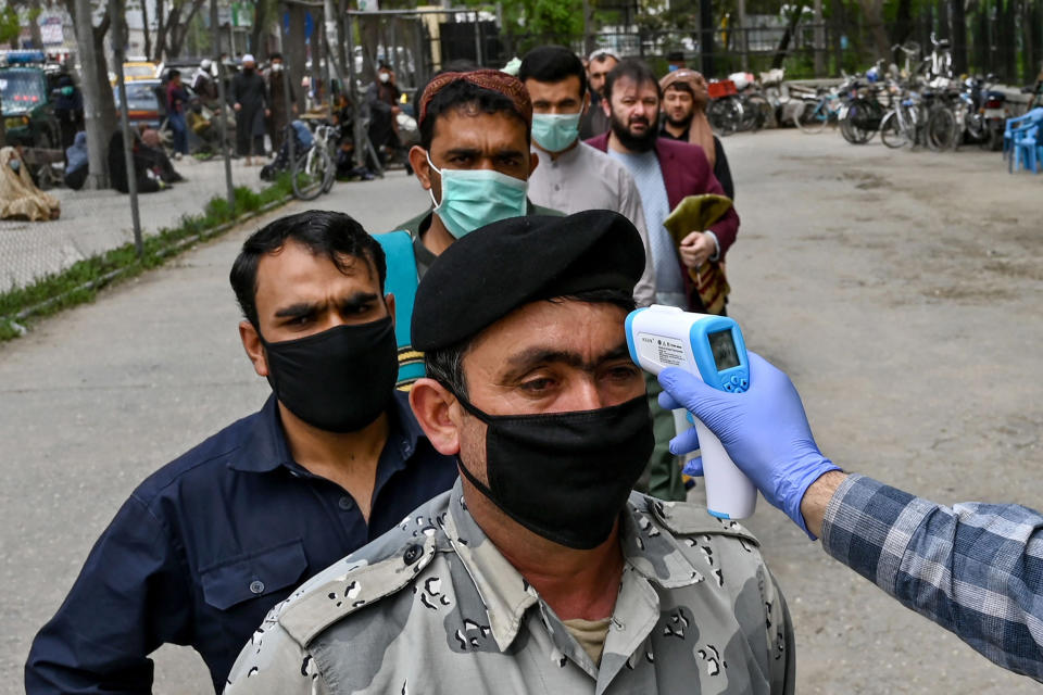 Image: A health worker checks the body temperature of a devotee as a preventive measure against the COVID-19 coronavirus before the Friday prayers on the first day of the Muslim holy month of Ramadan at Wazir Akbar Khan mosque (WAKIL KOHSAR / AFP - Getty Images file)