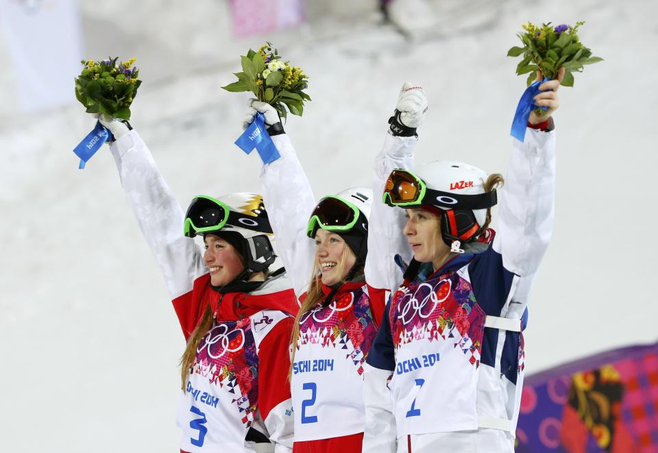 (L-R) Second-placed Chloe Dufour-Lapointe of Canada, winner Justine Dufour-Lapointe of Canada and third-placed Hannah Kearney of the U.S celebrate on the podium during the flower ceremony for the women's freestyle skiing moguls event at the 2014 Sochi Winter Olympic Games in Rosa Khutor, February 8, 2014. REUTERS/Mike Blake (RUSSIA - Tags: SPORT SKIING OLYMPICS)