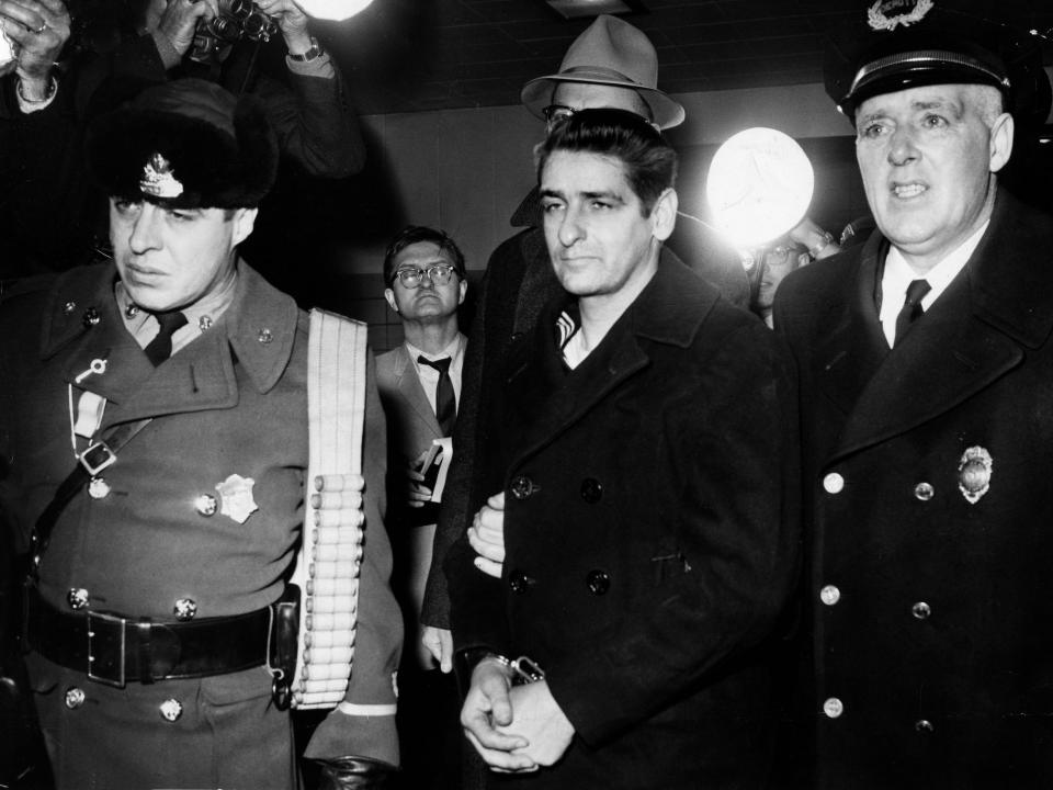 Albert DeSalvo wearing handcuffs is being taken to a cell by law enforcement in 1967.
