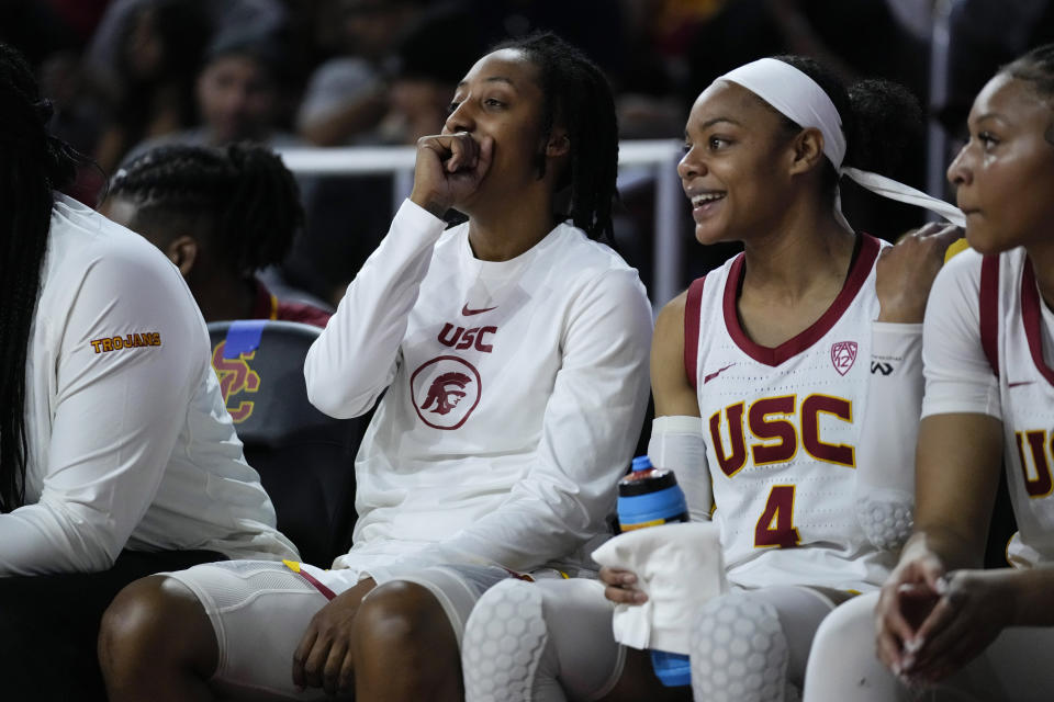 Southern California guard Aaliyah Gayles, center left, sits on the bench during the team's NCAA college basketball game against Washington in Los Angeles, Sunday, Jan. 28, 2024. (AP Photo/Ashley Landis)