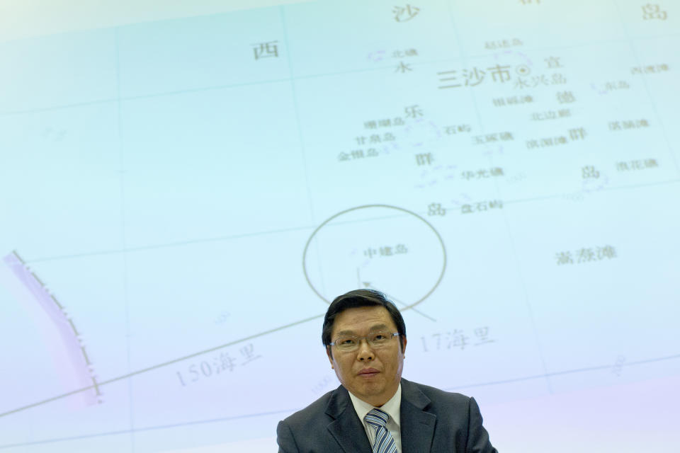 Yi Xianliang, deputy director-general of Chinese Ministry of Foreign Affairs' Department of Boundary and Ocean Affairs, stands up, in front of a map showing a disputed zone in South China Sea, to leave a press conference in Beijing, China, Thursday, May 8, 2014. Chinese and Vietnamese ships were locked in a tense standoff Thursday in disputed waters where Beijing is trying to set up an oil rig, a Vietnamese commander said, as the United States urged both sides to de-escalate tensions in the most serious incident in the South China Sea in years. (AP Photo/Alexander F. Yuan)
