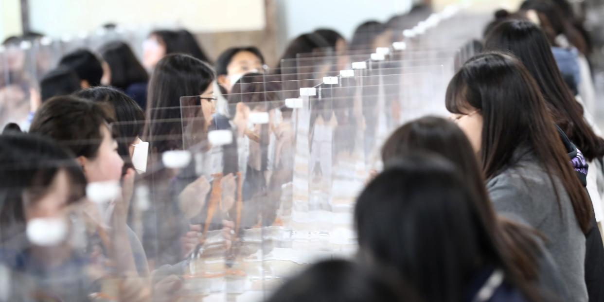 High school students eat lunch at a cafeteria with plastic screens on the table for preventing infection, as schools reopen following the global outbreak of the coronavirus disease (COVID-19), in Daejeon, South Korea, May 20, 2020. Yonhap/via REUTERS ATTENTION EDITORS - THIS IMAGE HAS BEEN SUPPLIED BY A THIRD PARTY. NO RESALES. NO ARCHIVE. SOUTH KOREA OUT. NO COMMERCIAL OR EDITORIAL SALES IN SOUTH KOREA.