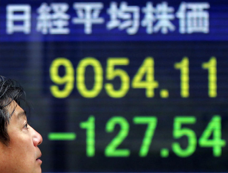 A man walks by the electronic stock board of a securities firm showing Japan's Nikkei 225 index, top left, dropped 127.54 points to 9,054.11 in Tokyo Wednesday, May 9, 2012. Asian stock markets fell Wednesday, spooked by disappointing U.S. corporate earnings and fears that political turmoil in debt-crippled Greece is pushing it closer to financial disaster. (AP Photo/Itsuo Inouye)