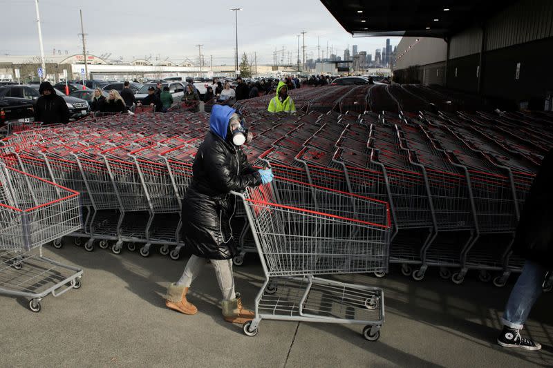 Dee Jackson wears a gas mask as she and other shoppers line up before opening at a Costco store, following reports of coronavirus disease (COVID-19) cases in the country, in Seattle