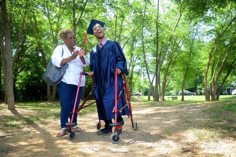 Saundra Adams, left, claps for her grandson Chancellor Lee Adams, right, as a small group of passerby joins in at Freedom Park Monday. Chancellor Lee will be graduating from Vance High School.