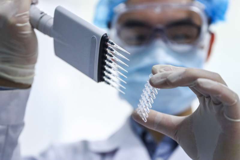 4月11日，工作人員在國藥集團中國生物新冠疫苗生產基地品質檢定部門對新型冠狀病毒滅活疫苗樣品進行雜質檢測。（新華社）