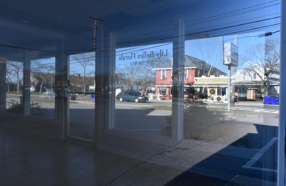 Thursday morning traffic is framed up in the old Asacks Footwear store along Main Street in Buzzards Bay. The building is to be demolished and a new building with commercial and residental space will be built in its place.