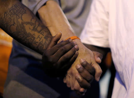 Father Michael Pfleger (C) holds hands in prayer with attendees at Saint Sabina Church before taking part in a weekly night-time peace march through the streets of a South Side neighborhood in Chicago, Illinois, U.S. September 16, 2016. REUTERS/Jim Young