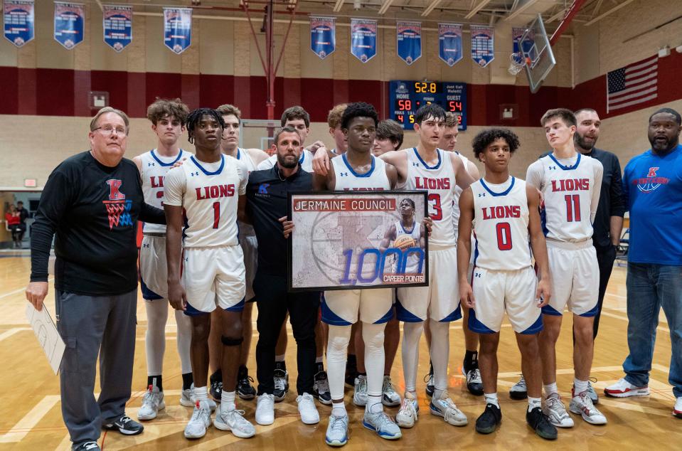 King's Academy Jermaine Council holds a poster with his team after scoring his 1000th point during his career at the school against Santa Fe Catholic in West Palm Beach, Florida on February 16, 2023.