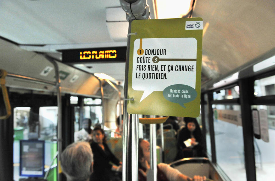 This Sept. 21, 2011 photo provided by Paris subway operator RATP, shows a campaign poster in a Paris bus. France, a country famed for its arrogant waiters and proud taxi drivers, is finally getting fed up with rudeness. Polling trends show that impoliteness is now topping lists on causes of stress for the French, who lament that people don't say "thank you" anymore. Paris public transport is weighing in, with a summer-long publicity campaign poking fun at gallic incivility. Poster reads: A Bonjour, doesn't cost a thing." (AP Photo/Bruno Marguerite, RATP)