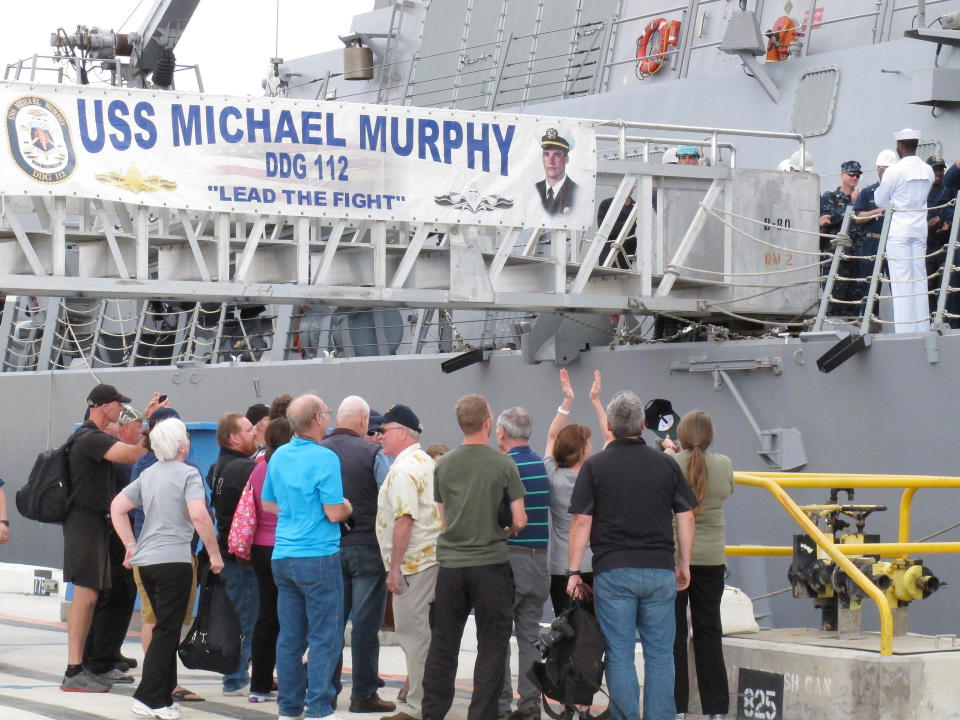 Passengers from a disabled Canadian naval ship applaud crew members of the American naval destroyer USS Michael Murphy after being escorted to Pearl Harbor, Hawaii, Tuesday, March 4, 2014. A U.S. Navy ocean tug was towing the Canadian ship after an engine fire left 20 sailors with minor injuries. (AP Photo/Oskar Garcia)