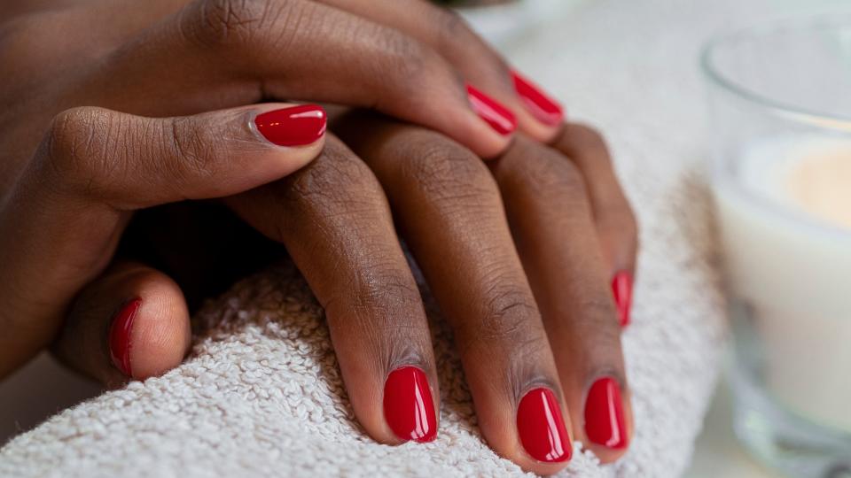 Hands with short, squared red nails